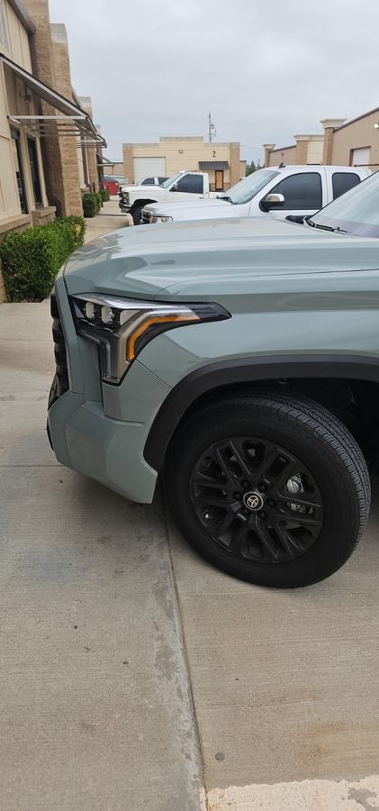 Gray-green pickup front fender and headlight after repair