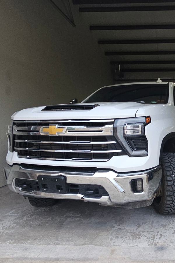 White heavy-duty pickup front end after repair, inside the shop