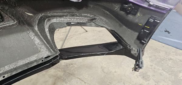 Carbon fiber body kit component resting on the shop floor