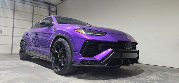 Front three-quarter view of a purple SUV with an aggressive front splitter in the shop