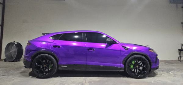 Side profile of a purple SUV in the shop