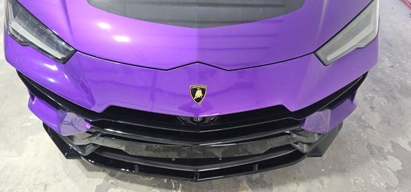 Close-up of a purple front bumper with a black carbon splitter