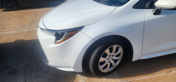 White sedan front bumper, headlight and fender after repair and refinish
